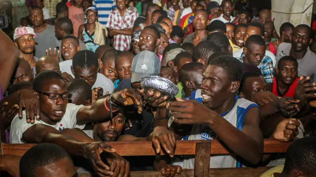 Haitianos que chegaram em grande número ao Acre em 2013 tiveram que se aglomerar em alojamentos e disputavam a marmita