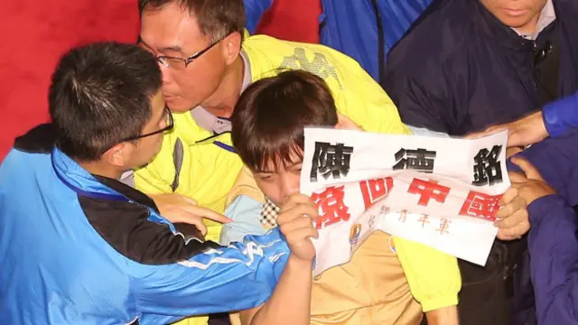 台联青年军成员举牌抗议被警方带走。