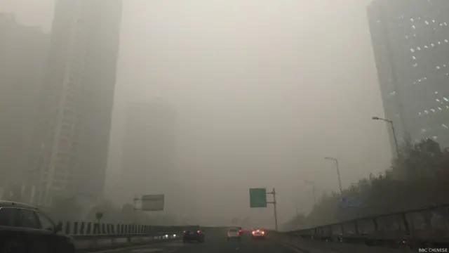 在雾霾中无法见到北京高楼的全貌。