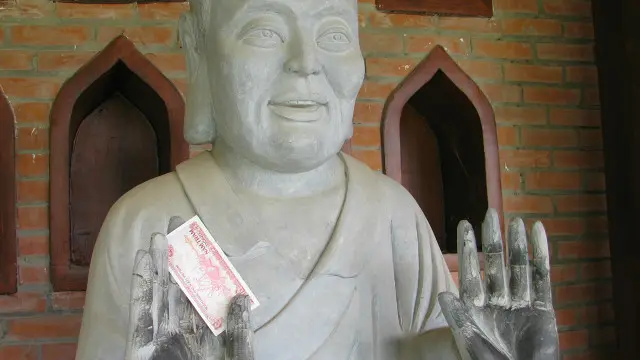 Nhét tượng vào tay tượng Phật tại chùa Bái Đính, một trong những công trình do ông Nguyễn Văn Trường đầu tư