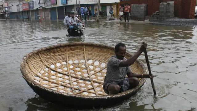 बाढ़ के कारण सड़क पर नाव और मोटरसाइकिल