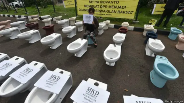 Sejumlah pengunjuk rasa menyusun toilet di depan gedung DPR di Jakarta pada Kamis (03/12) kemarin sebagai simbol 'busuk dan kotor'.