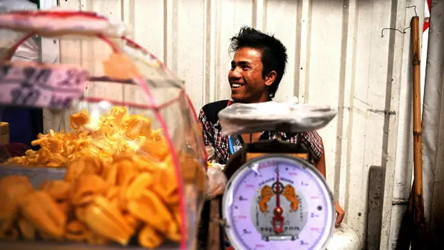 Уличный торговец в Бангкоке развлекается в течение всего рабочего дня