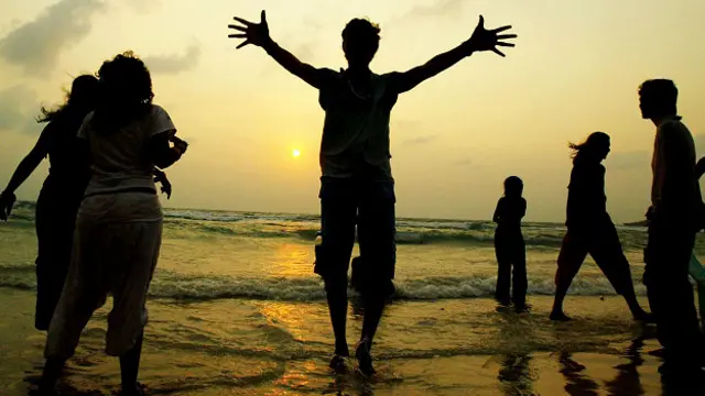 Туристы радуются празднику полнолуния на пляже