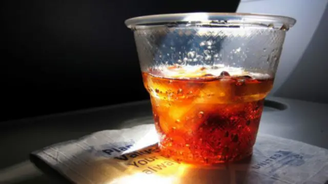 在30000英尺的高空上，阳光穿过一杯朗姆和可乐。（图片来源：Denise Taylor/Getty）