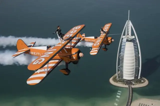 فريق برايتلينغ يحلق فوق برج العرب بدبي، والرياضيتان ماري كيلربي وساره تانر تقومان بالمشي على الاجنحة