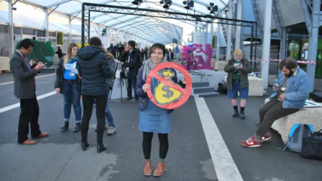 一名跟踪会议的青年举着象征着对最不发达国家资金支持不够的标志。