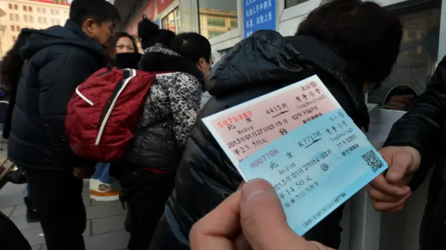 北京火車站外一名旅客展示其剛買到的火車票（資料圖片）