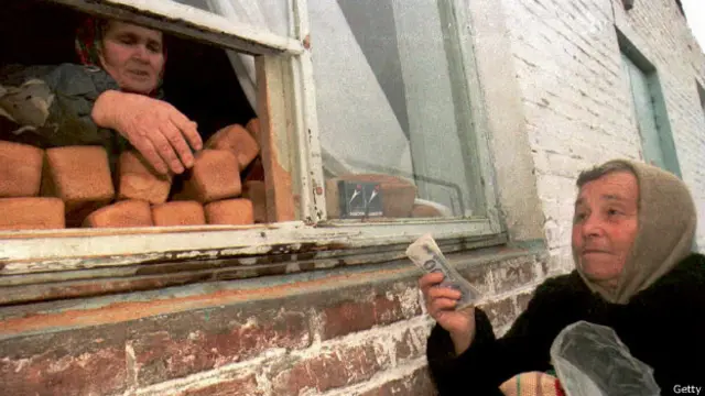 Пожилая русская женщина покупает хлеб