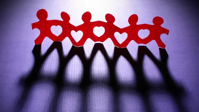 Unas figuras de papel agarradas de la mano