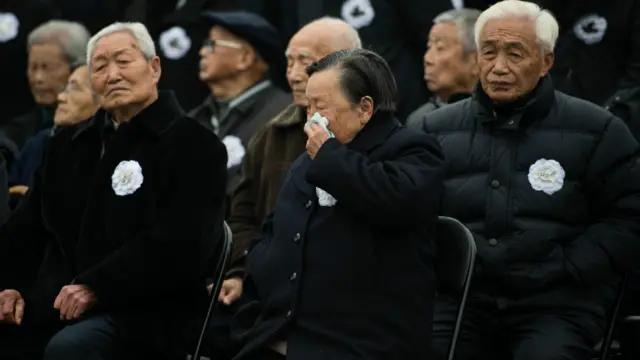 南京大屠杀幸存者夏淑琴(中)在国家公祭仪式上擦泪(新华社图片13/12/2015)