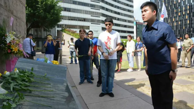 台湾青年王炳忠（右）向抗日纪念碑献花。