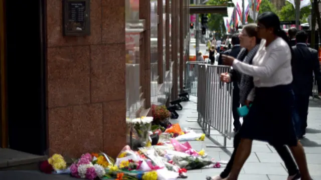 Karangan bunga diletakkan di trotoar di dekat kafe Lindt di kawasan Martin Place, Sydney, Australia.