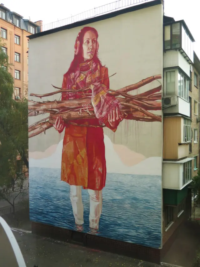 Мурал, дівчина з дровами