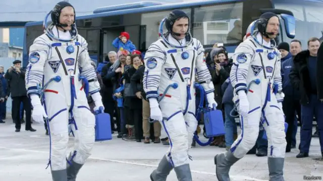 मेजर पीक रुसी अन्तरिक्ष यात्री युरी मेलेन्चेन्को (बीचमा) र अमेरिकी अन्तरिक्ष यात्री टीम कोप्रा सहित उड्दैछन्। 