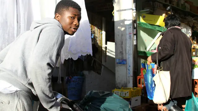 Damiloa, du Nigéria, aide sa famille sur le marché de Dalston. Il est chargé d'aider les clients à amener les marchandises dans leur voiture. Il se dit heureux de servir des clients venant des quatre coins du continent.