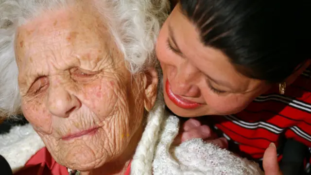 Mujer de más de cien años junto a familiar