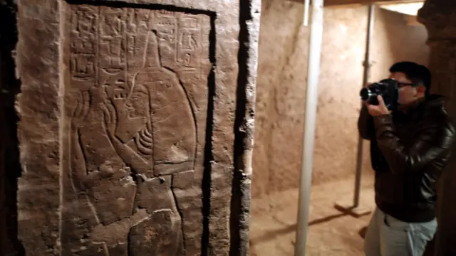 زائر يصور الجداريات في قبر مايا. (EPA)