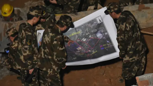 救援人員22日凌晨在現場查看地圖，制定救援方案。