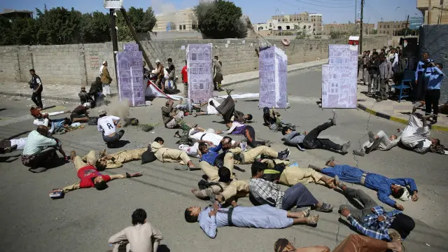 يمنيون يقدمون منتصف الشهر الماضي عرضا تمثيليا، أمام مقر الأمم المتحدة في صنعاء، لمدنيين قتلوا في غارات لطائرات التحالف بقيادة السعودية. 