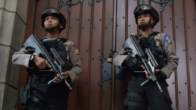 Dua anggota polisi menjaga gereja Katedral Jakarta saat Natal 2015.