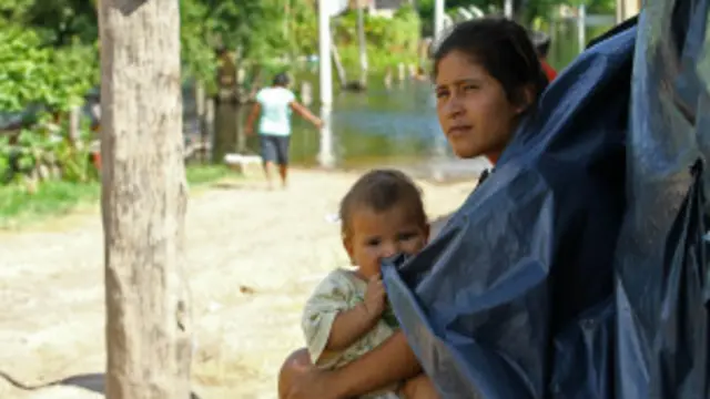 Una mujer con su hijo, desplazados por las aguas.