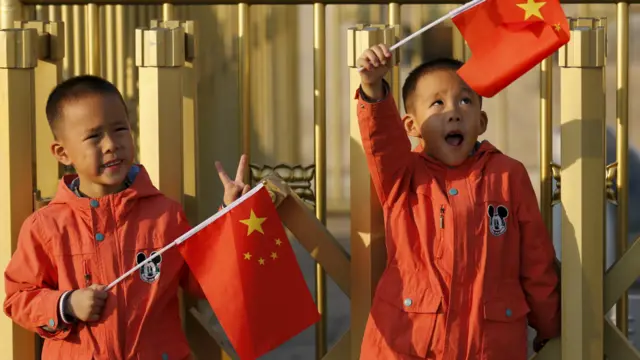 一对中国双胞胎兄弟在天安门前手持小国旗