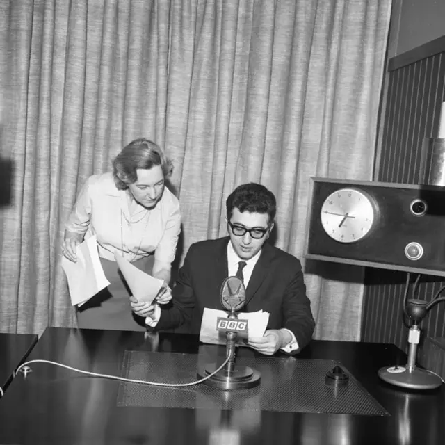 فریدون نیک‌آیین در حال آماده شدن برای خواندن خبر به همراه منشی بخش فارسی