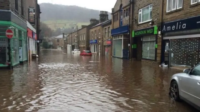 Hebden Bridge 的商店街和汽车都被淹在水中。