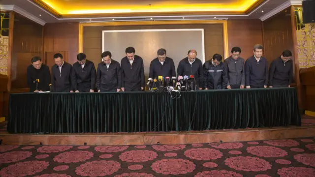 马兴瑞（左六）与许勤（左七）等为光明新区滑坡事故鞠躬道歉（新华社图片25/12/2015）