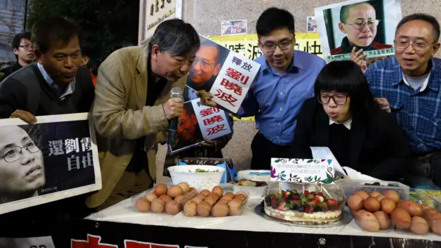 香港支联会秘书李卓人（左二）与示威者在铜锣湾集会上为刘晓 波的生日蛋糕吹蜡烛（28/12/2015）