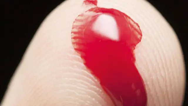 Капля крови на пальце