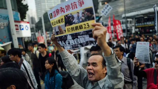 一名参与香港元旦的示威者拿起标语