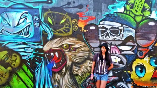 Adalid bergaya di depan seni grafiti di tanah airnya, Filipina (Credit: Aileen Adalid).