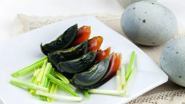 Irisan telur abad yang hitam mengkilap.