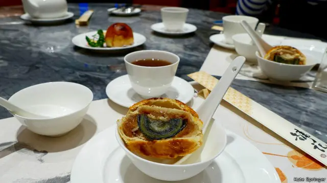 Di balik kulit kerak roti, terdapat telur abad yang berwarna hitam dan hijau.