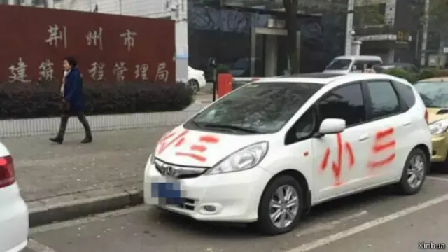 荆州市沙市区塔桥路上，一辆白色小车四周被红色油漆涂写了多个“小三”，引发路人围观。