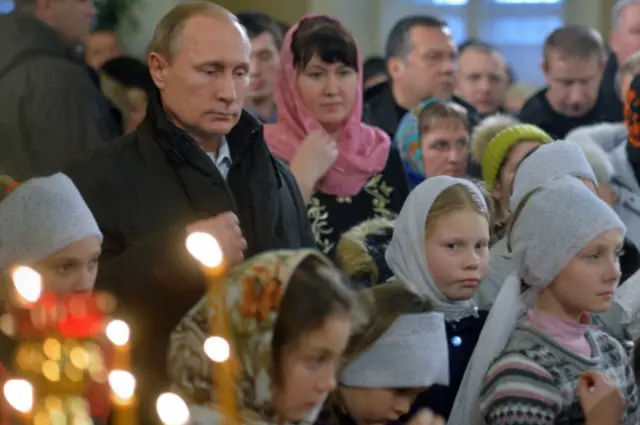 Presiden Rusia Vladimir Putin menghadiri misa tengah malam di sebuah gereja di Desa Turginovo, sekitar 150 km barat laut Moskow.