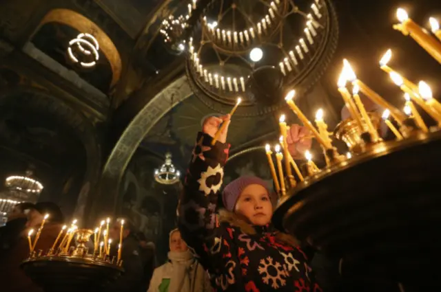 Di Katedral St Volodymyr di Kiev, Ukraina, umat Kristen Ortodoks menyalakan lilin untuk menandai Natal, dan para pemberontak menawarkan pembebasan para tahanan di malam Natal itu. 