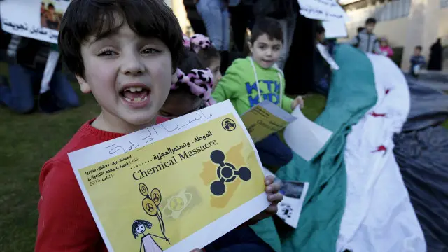 أطفال سوريون يحملون لافتات أمام مقر الأمم المتحدة في لبنان للمطالبة برفع الحصار عن مدينة مضايا.