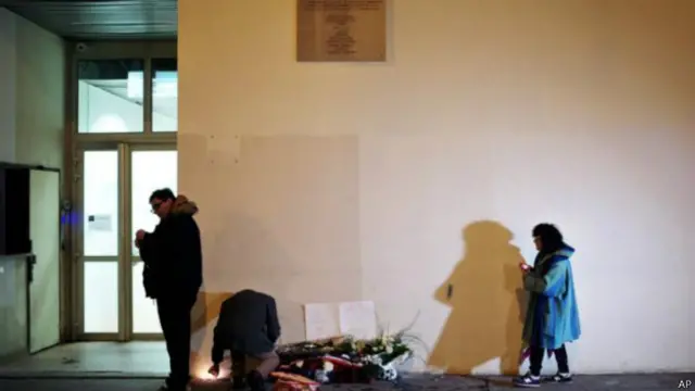 在《查理周刊》所在的街道上，哀悼者三三两两驻足悼念死难者。