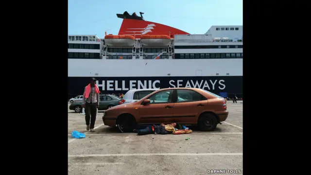 Мужчина спит у припаркованной в порту машины