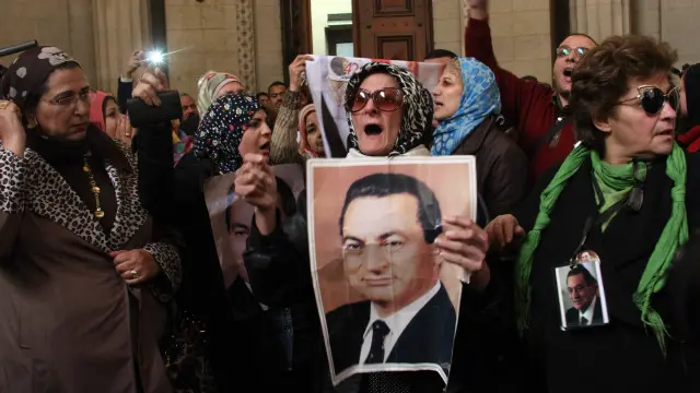 بعض أنصار مبارك يرفعون صوره أمام المحكمة.