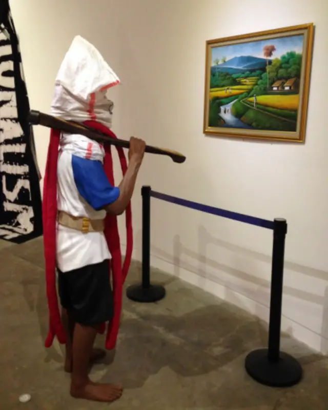 Karya Eko Nugroho berjudul "Disekap Kesejahteraan, Dibutakan Kebahagiaan".