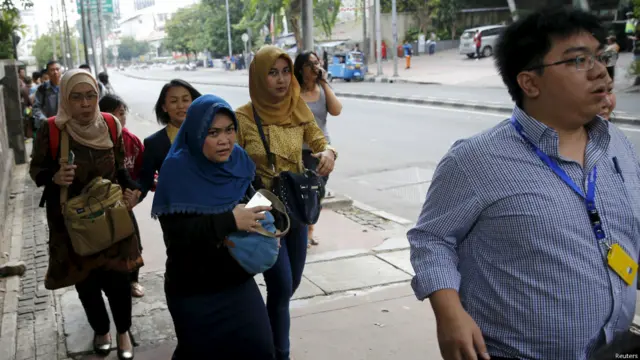Orang-orang melakukan evakuasi diri dari kantor mereka di kawasan Sarinah, Thamrin, Jakarta.