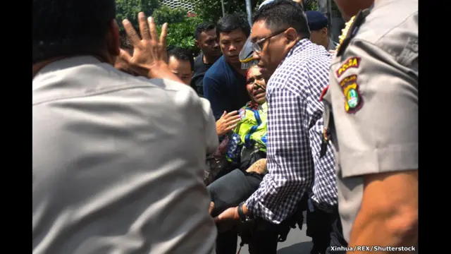 Раненого полицейского уносят