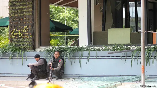 Dua anggota kepolisian berjaga di luar kafe Starbucks setelah serangan berakhir.