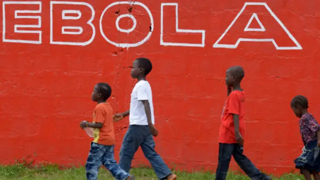 أطفال أمام سور كُتب عليه إيبولا