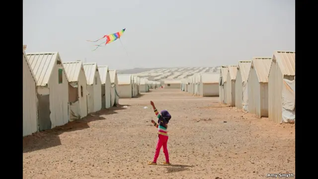 Una niña jugando con una cometa en un campo de refugiados