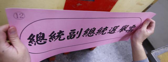 台北某投票站選舉工作人員為投票箱貼上標示（15/1/2016）
